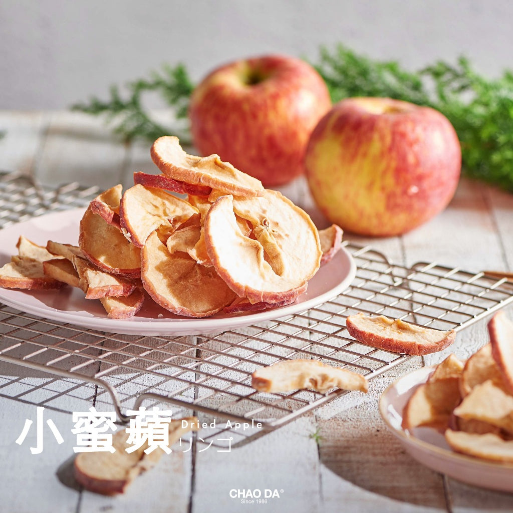 Dried apples on a plate with fresh apples in the background