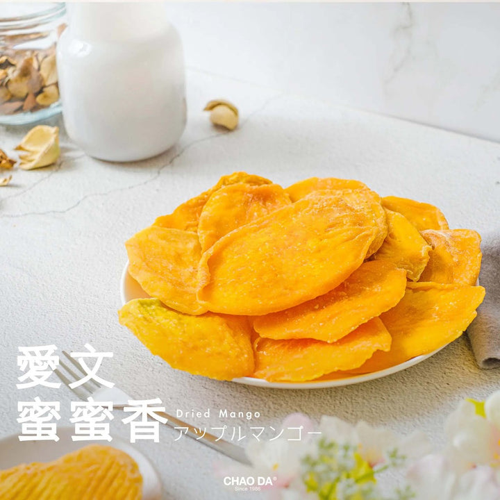 Dried mangoes on a plate with a white container and jar in the background.