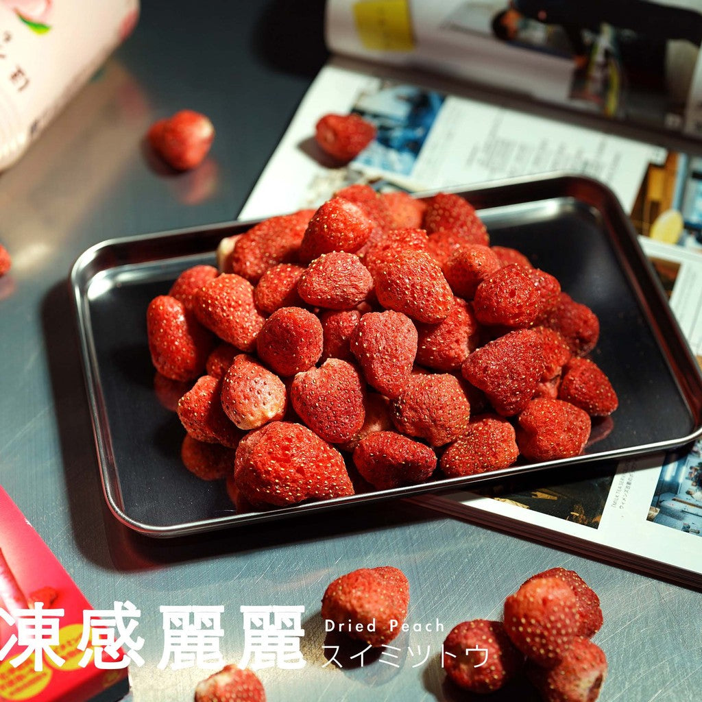 Dried red fruits on a metal tray with a magazine in the background