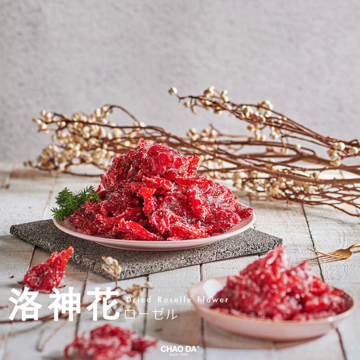 Red flower petals on a white plate with gold branches in the background
