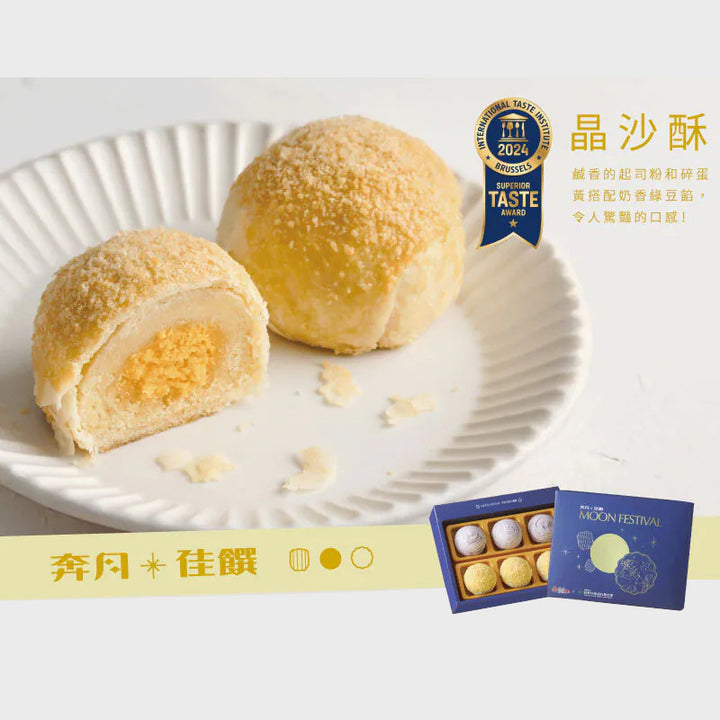 Two mooncakes on a white plate with a box of mooncakes and a blue award badge in the background.