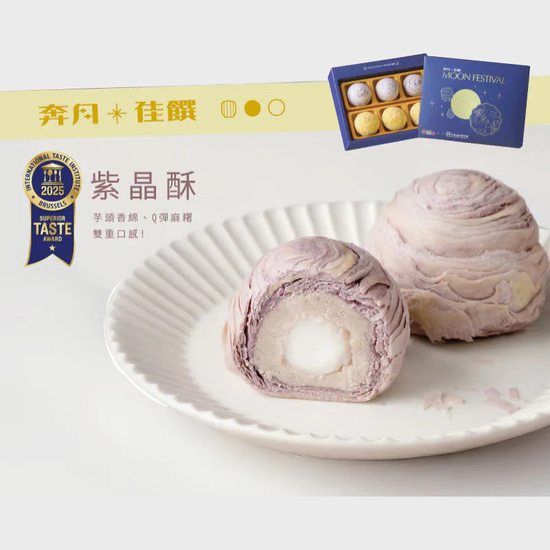 Two purple mooncakes on a white plate with a box of mooncakes in the background.