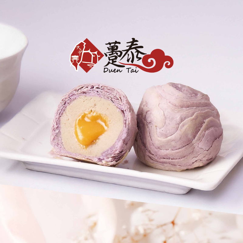 Two purple and white pastries with a yellow filling on a white plate, branded 'Duen Tai'.