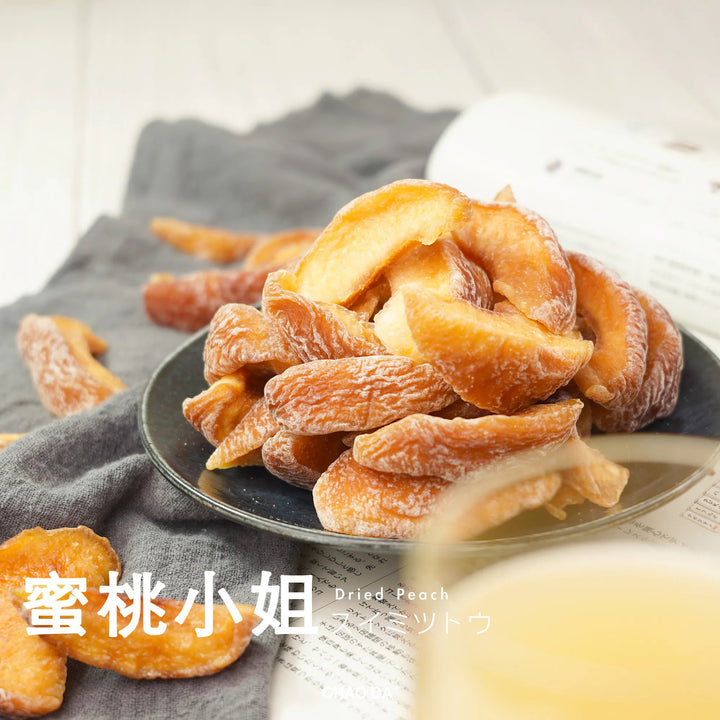 Dried apricots in a white bowl on a gray surface with 'CHAO DA' branding.