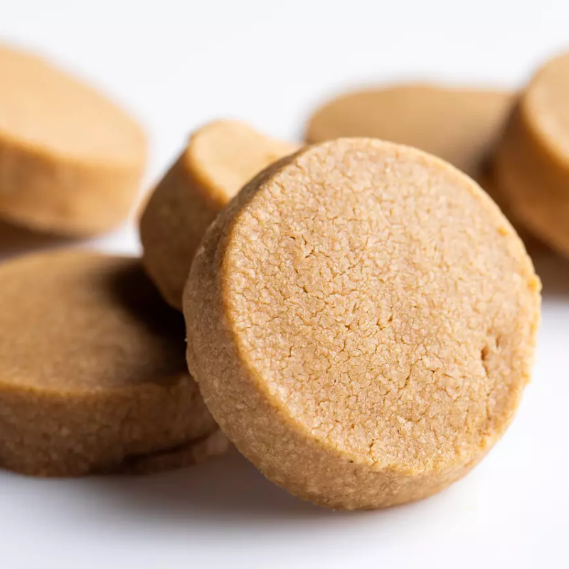 Close-up of round, brownish-beige cookies on a white background
