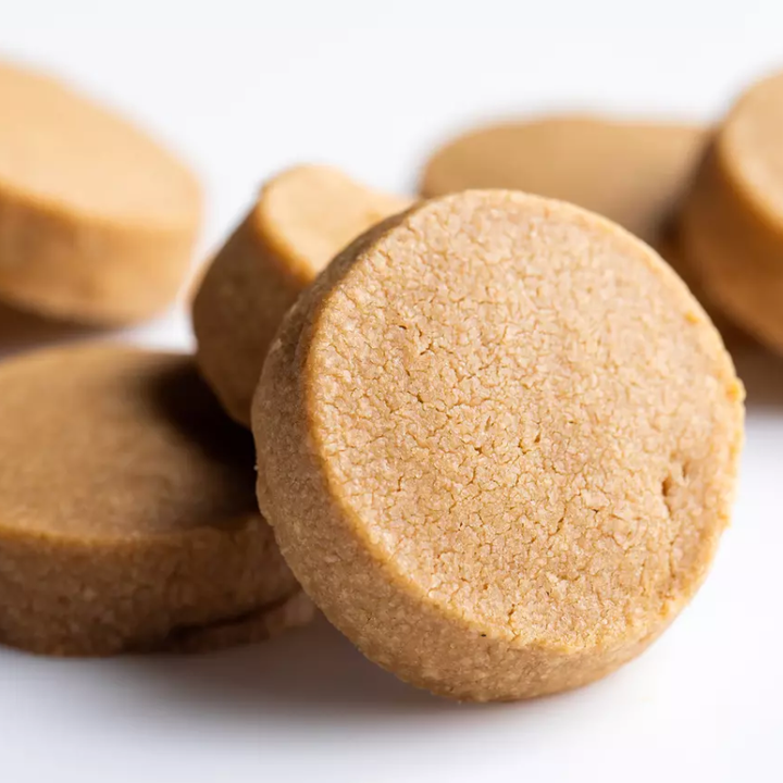 Close-up of round, brownish-beige cookies on a white background