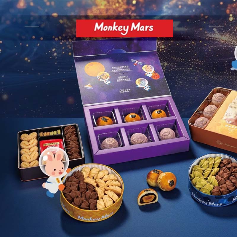 Assorted snacks in open boxes with 'Monkey Mars' branding on a blue background.