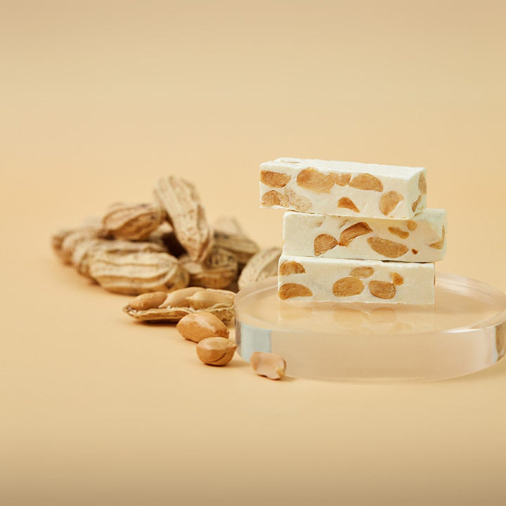 Stack of bars with peanut pieces on a beige background