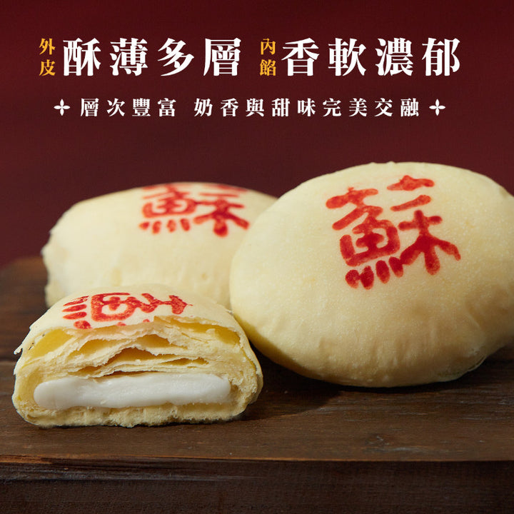 Three mooncakes with red text on a wooden surface, with one cut open to show layers.