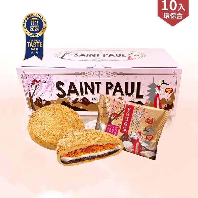 Box of Saint Paul cookies with a cookie cut in half on a pink background