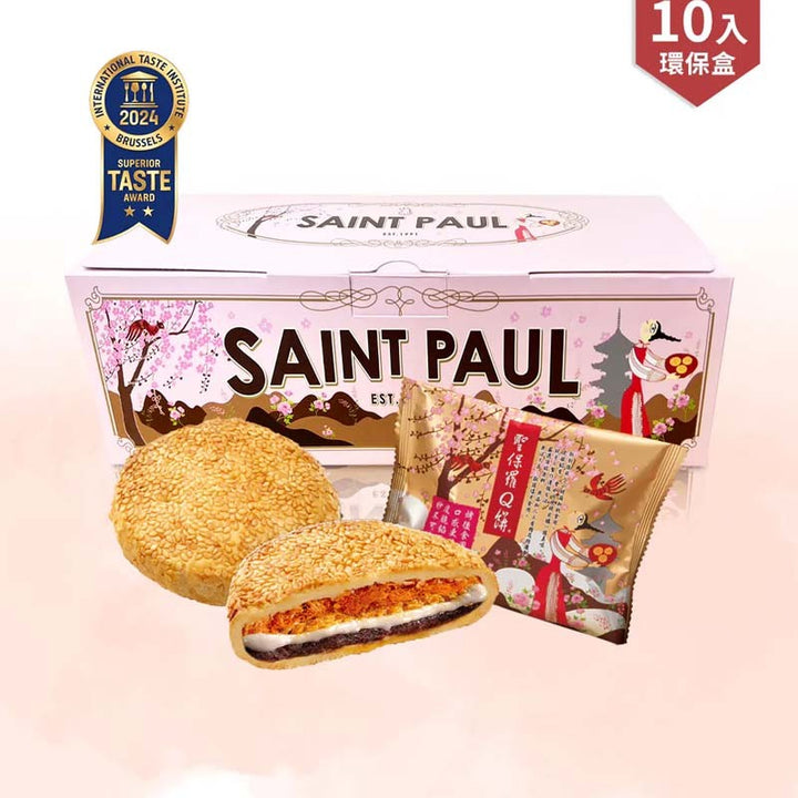 Box of Saint Paul cookies with a cookie cut in half on a pink background