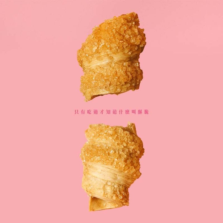 Two golden-brown fried dough sticks on a pink background with Chinese text.