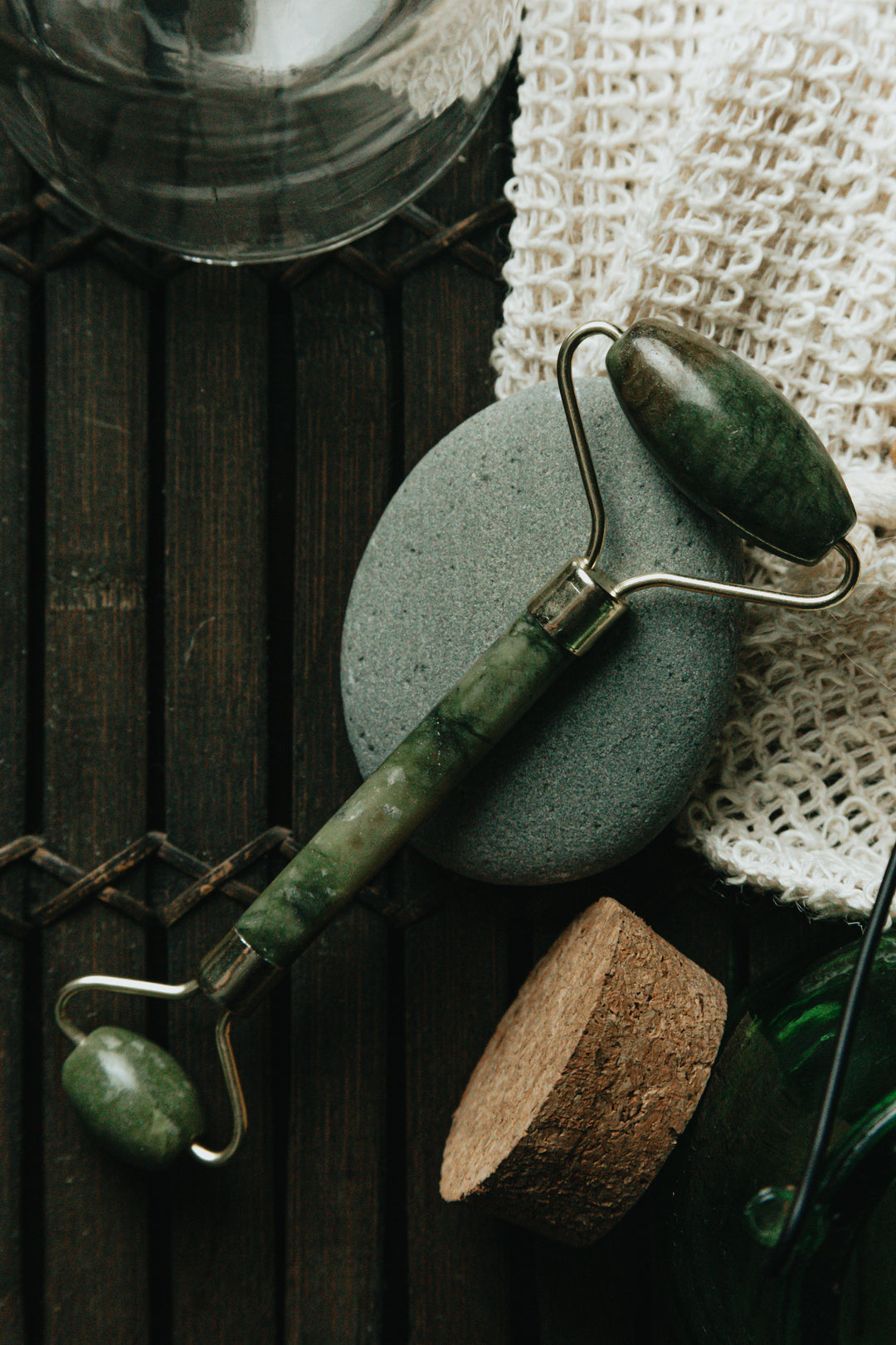 FLATLAY-OF-JADE-FACE-ROLLER-LAYING-ON-A-GREY-STONE